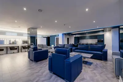 a lobby with blue couches and a bar at Temple Court Cavern Quarter Apartments by Happy Days in Liverpool
