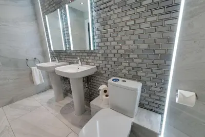 a bathroom with a toilet and a sink and a mirror at Temple Court Cavern Quarter Apartments by Happy Days in Liverpool
