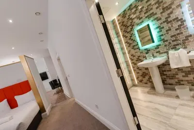 a bathroom with a sink and a mirror at Temple Court Cavern Quarter Apartments by Happy Days in Liverpool