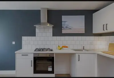 a kitchen with white cabinets and a stove top oven at The Residency rooms Liverpool in Wallasey