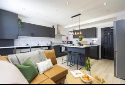 a living room with a couch and a kitchen at The Residency rooms Liverpool in Wallasey