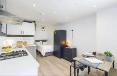 a kitchen and living room with a bed and a table at The Residency rooms Liverpool in Wallasey