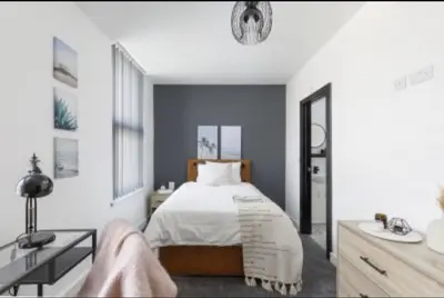 a bedroom with a bed and a desk and a sink at The Residency rooms Liverpool in Wallasey
