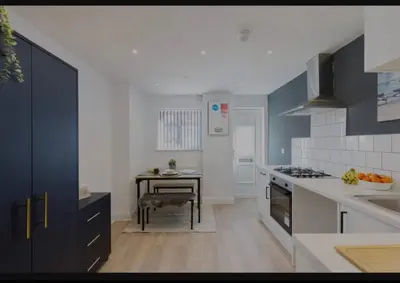 a kitchen with a sink and a table in it at The Residency rooms Liverpool in Wallasey