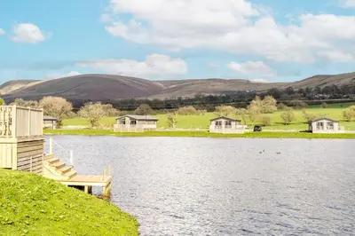 a view of a lake with houses and a dock at Pendle View Retreat - Holiday Park in Clitheroe