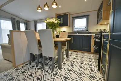 a kitchen with a wooden table and chairs at Pendle View Retreat - Holiday Park in Clitheroe