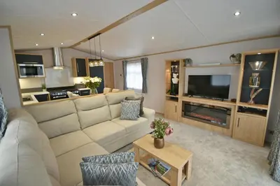 a living room with a couch and a television at Pendle View Retreat - Holiday Park in Clitheroe