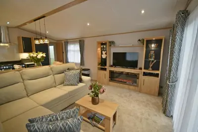 a living room with a couch and a television at Pendle View Retreat - Holiday Park in Clitheroe