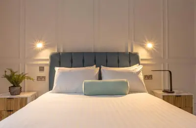 a bed with a blue pillow on top of it at Winckley Chambers in Preston