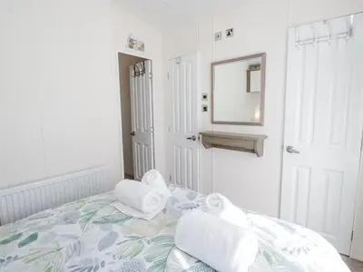a bedroom with a bed with towels on it at Lakeside Haven in Carnforth