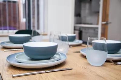 a wooden table with blue bowls and plates and glasses at Reduced Price, Long or Short Stays, Free Parking in Liverpool