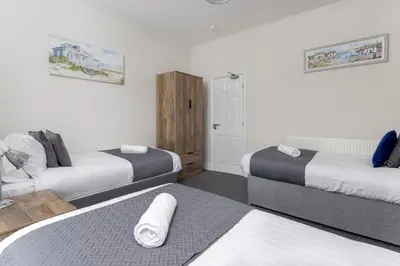 a room with three beds in a room at Newcombe House - Air Host & Stay - Free Parking - Contractor Friendly in Liverpool