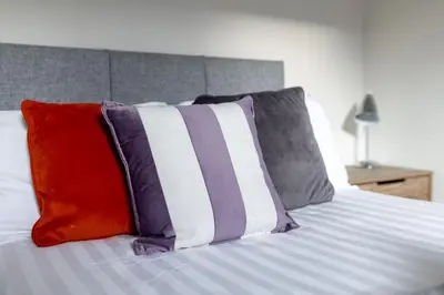 a bed with colorful pillows on top of it at Newcombe House - Air Host & Stay - Free Parking - Contractor Friendly in Liverpool