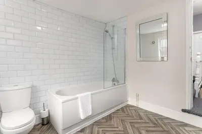 a white bathroom with a tub and a toilet at Newcombe House - Air Host & Stay - Free Parking - Contractor Friendly in Liverpool