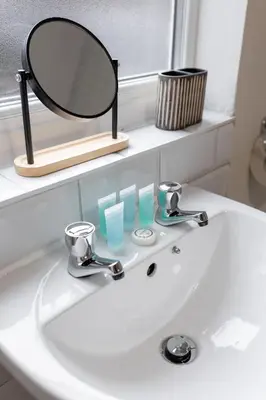 a bathroom sink with a mirror on top of it at Newcombe House - Air Host & Stay - Free Parking - Contractor Friendly in Liverpool