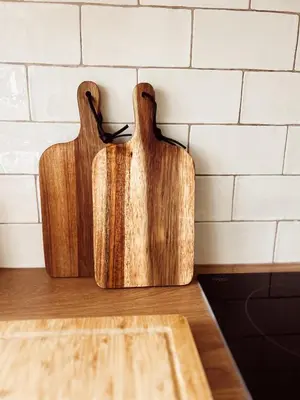 two wooden cutting boards sitting on top of a counter at Holly Cottage in Cartmel