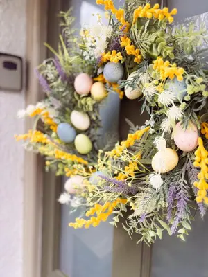 a wreath with easter eggs and flowers on a door at Holly Cottage in Cartmel
