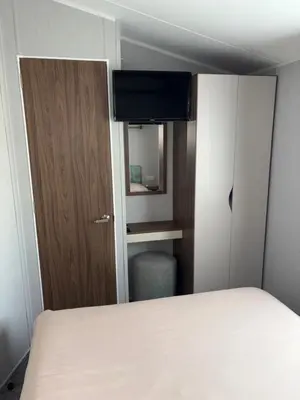 a small room with a bed and a mirror at McCanns Caravan Marton Mere in Blackpool