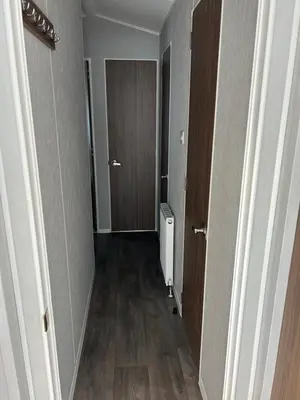 an empty hallway with two doors and a hallway at McCanns Caravan Marton Mere in Blackpool
