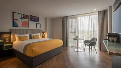 a hotel room with a bed and a table and a chair at Maldron Hotel Liverpool City Centre in Liverpool