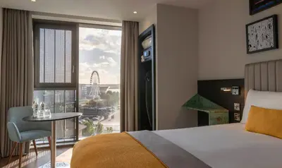 a hotel room with a bed and a large window at Maldron Hotel Liverpool City Centre in Liverpool