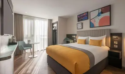 a hotel room with a bed and a desk at Maldron Hotel Liverpool City Centre in Liverpool