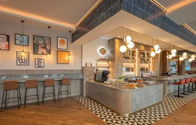 a restaurant with a bar with bar stools at Maldron Hotel Liverpool City Centre in Liverpool