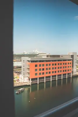 a large orange building next to a body of water at 2BR Apt - Balcony - River View in Liverpool