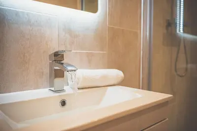 a bathroom with a sink with water coming from a faucet at 2BR Apt - Balcony - River View in Liverpool