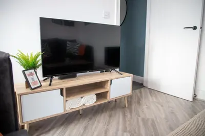 a living room with a tv on a stand at Beach Apartments - 1st Floor Cleveleys in Cleveleys