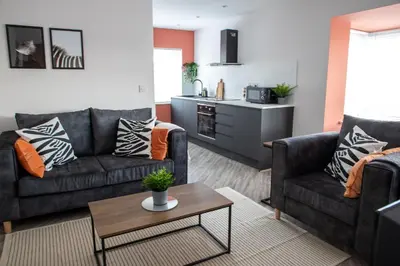 a living room with two couches and a table at Beach Apartments - 1st Floor Cleveleys in Cleveleys