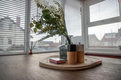 a table with a vase with a plant in it at Beach Apartments - 1st Floor Cleveleys in Cleveleys