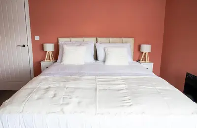 a bedroom with a white bed with two lamps at Beach Apartments - 1st Floor Cleveleys in Cleveleys