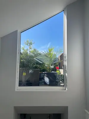 a window in a white wall with a view of plants at East Cliff in Preston
