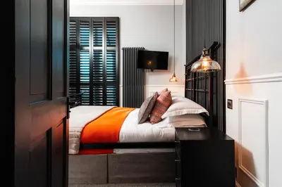 a bedroom with a bed with an orange blanket at East Cliff in Preston