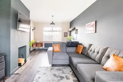 a living room with a gray couch and a table at T'house in wigan in Pemberton