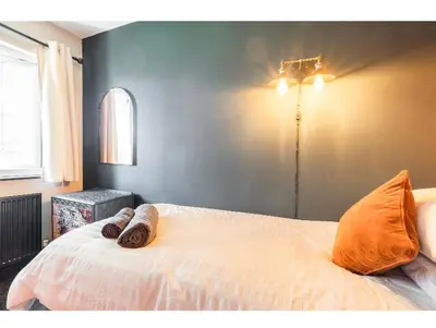 a bedroom with a bed with orange pillows on it at T'house in wigan in Pemberton