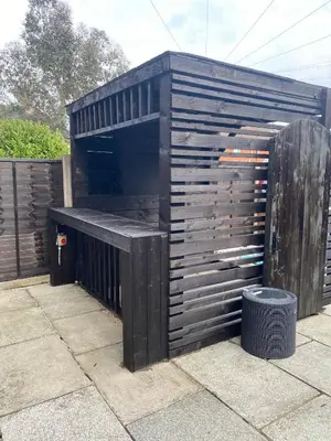 a black shed sitting on top of a patio at T'house in wigan in Pemberton