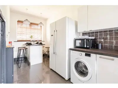 a kitchen with a washing machine and a microwave at T'house in wigan in Pemberton