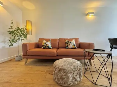 a living room with a brown couch and a table at The Wilsons Courtyard, 2 - Bed, Sleeps 4, Pets Welcome in Ulverston