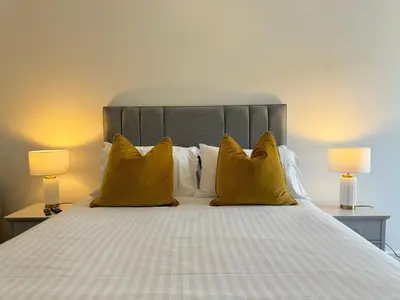 a bedroom with a large bed with yellow pillows at The Wilsons Courtyard, 2 - Bed, Sleeps 4, Pets Welcome in Ulverston