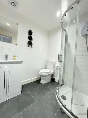 a bathroom with a toilet and a glass shower at The Wilsons Courtyard, 2 - Bed, Sleeps 4, Pets Welcome in Ulverston
