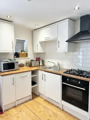 a kitchen with white cabinets and a stove top oven at The Wilsons Courtyard, 2 - Bed, Sleeps 4, Pets Welcome in Ulverston