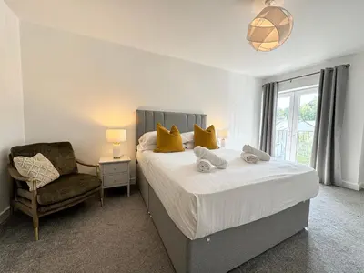a bedroom with a bed with a chair and a window at The Wilsons Courtyard, 2 - Bed, Sleeps 4, Pets Welcome in Ulverston