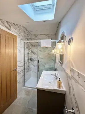 a bathroom with a shower and a sink and a mirror at Converted Barn with Hot Tub, The Hayloft. in Carnforth