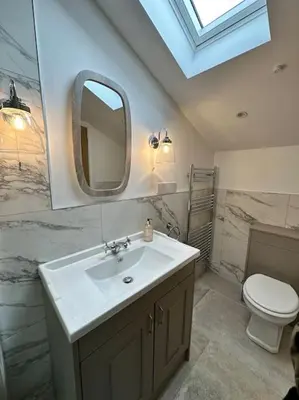 a bathroom with a sink and a toilet and a mirror at Converted Barn with Hot Tub, The Hayloft. in Carnforth