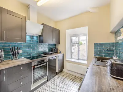 a kitchen with gray cabinets and a table and a window at Cartmel Place in Cartmel