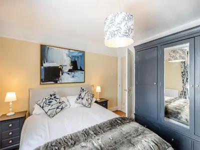 a bedroom with a white bed and a chandelier at Cartmel Place in Cartmel