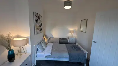 a small bedroom with a bed and two lamps at The road to Wigan Pier in Pemberton