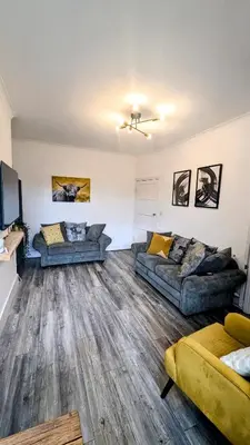 a living room with two couches and a tv at The road to Wigan Pier in Pemberton